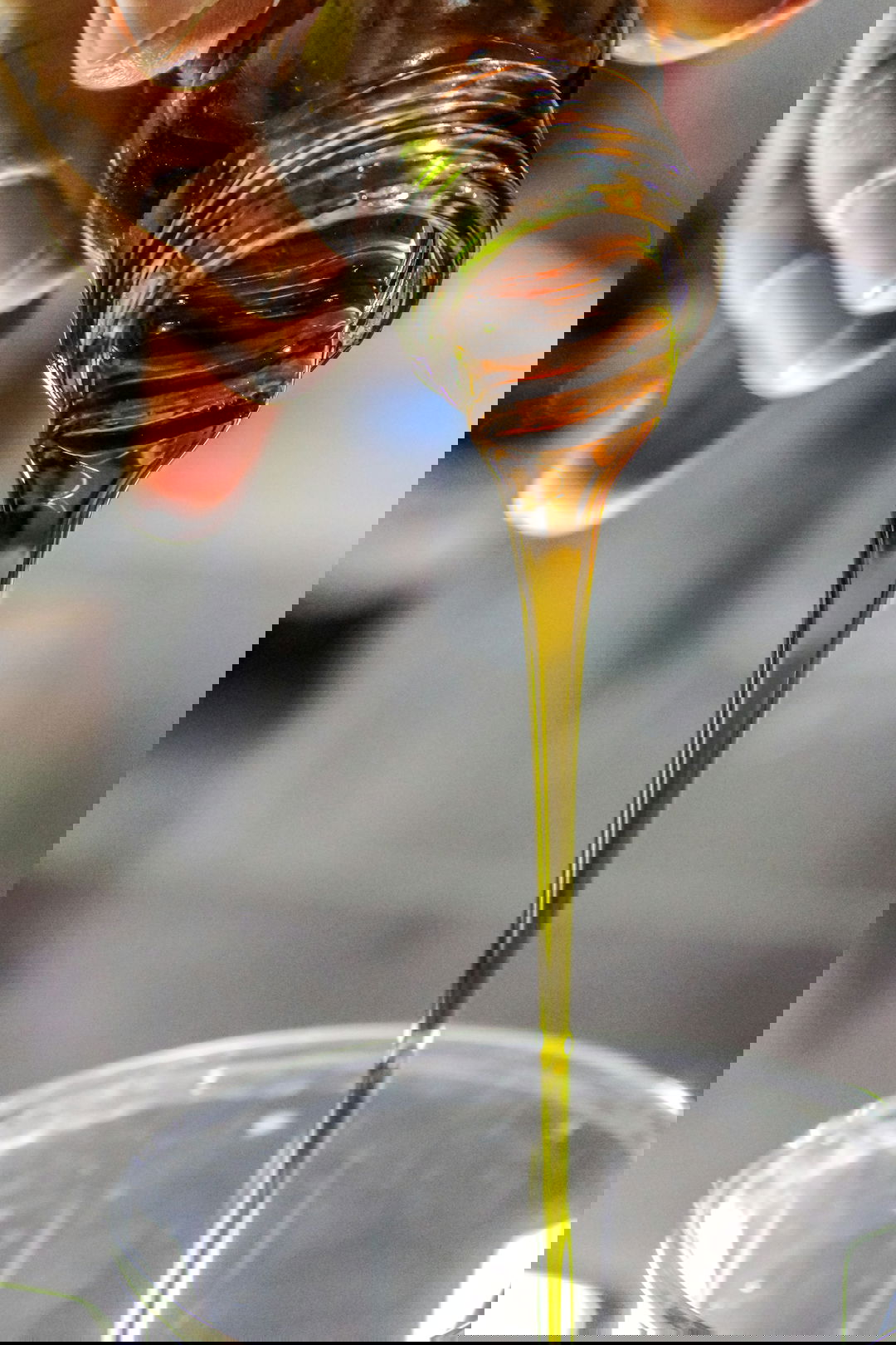 person holding clear drinking glass with brown liquid